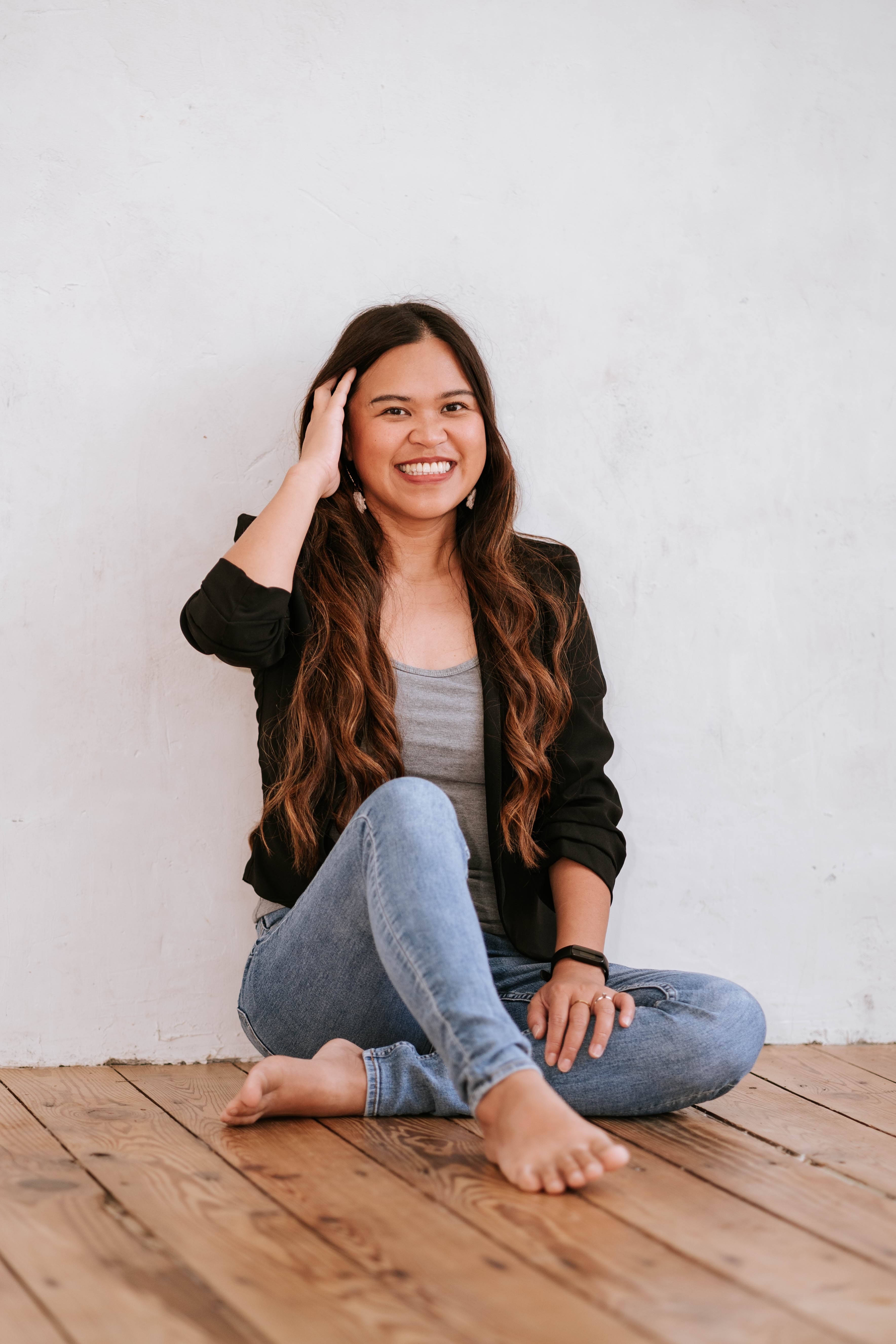 Kristy Yoder smiling, seated against a bright studio wall